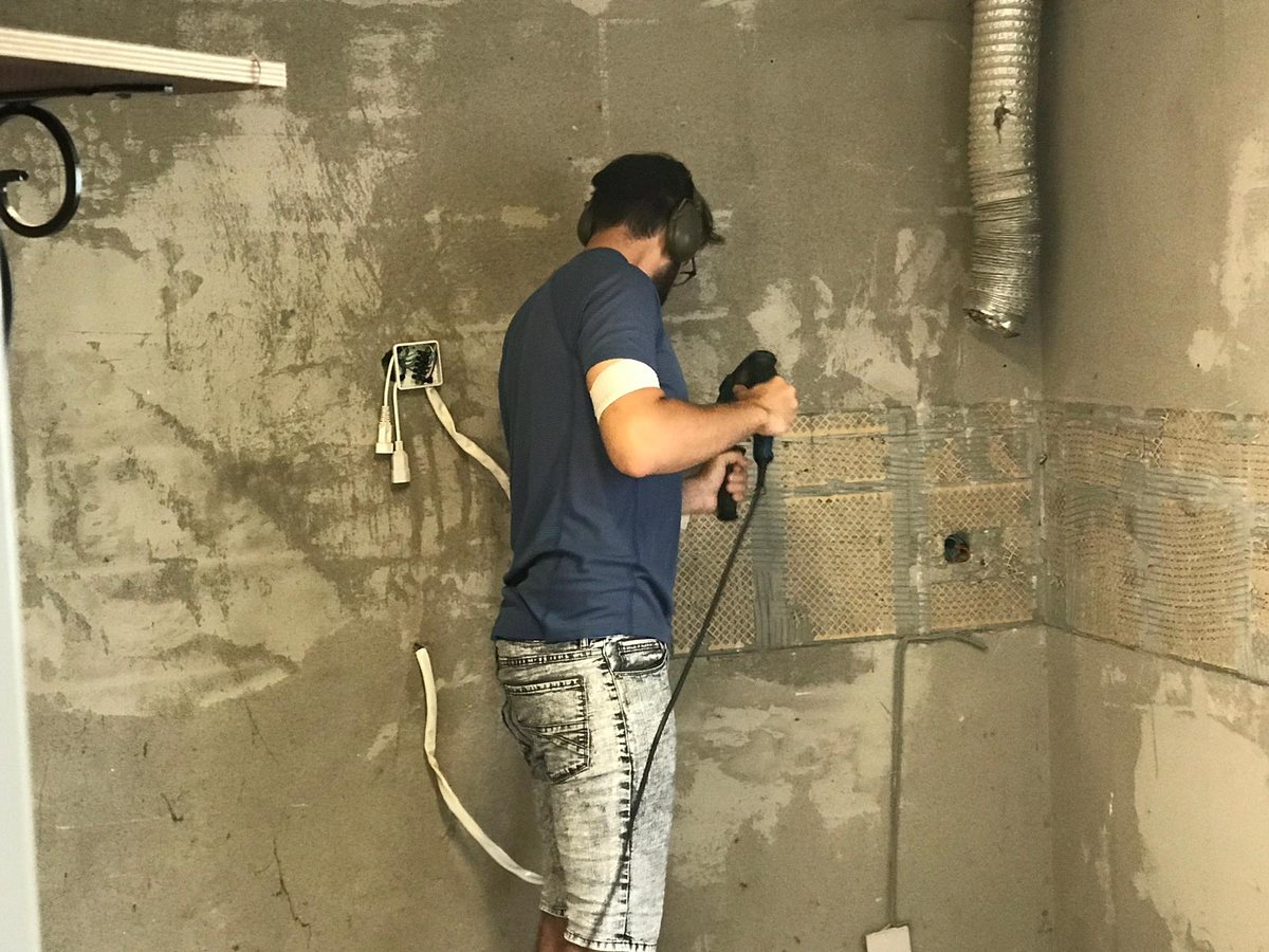 Der Elektriker beim Schlitzen einer Küchenwand